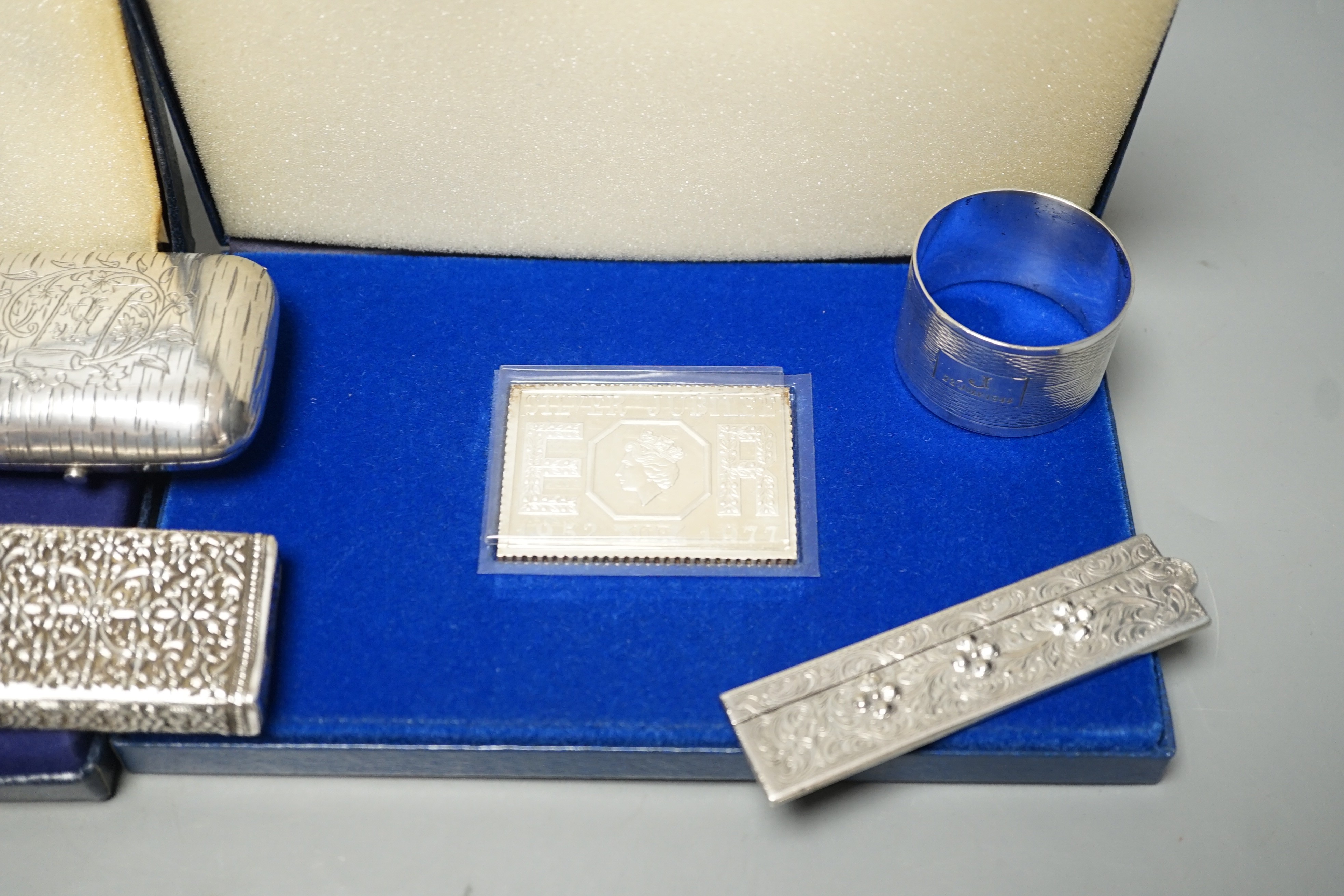 Small silver items including two napkin rings, a modern cased commemorative plaque and replica stamp, together with four white metal items including a Russian mounted purse.
